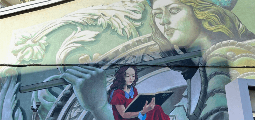 Mural of a woman reading and the goddess of culture"