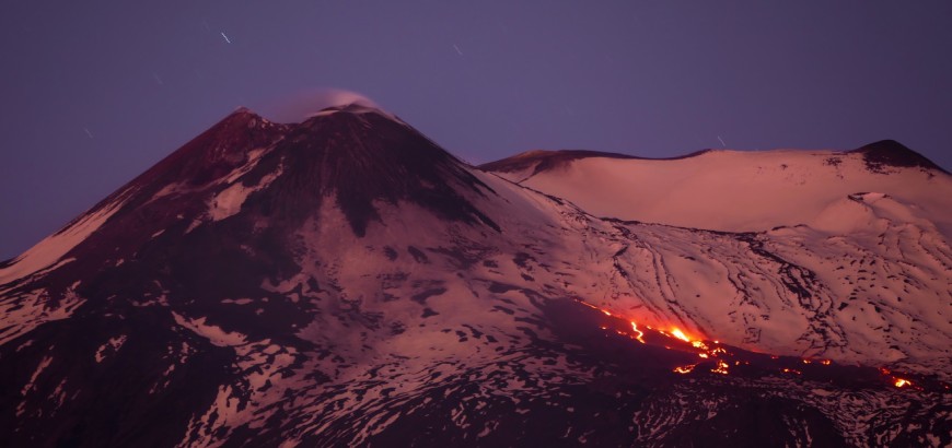 Suggestivo panorama dell'etna innevata durante un'attività eruttiva